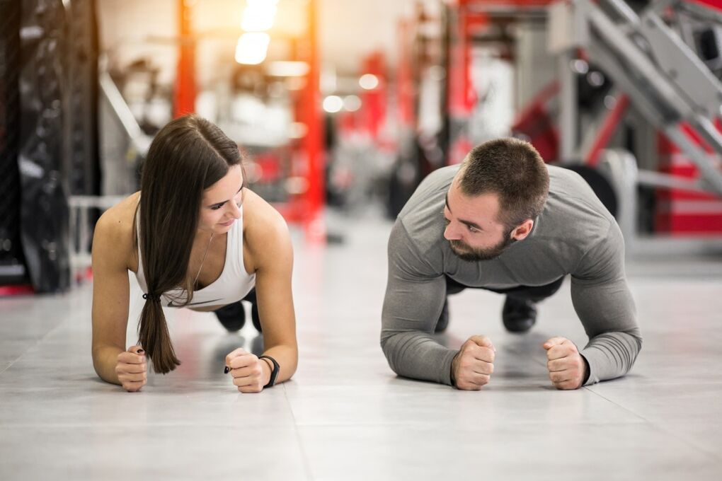 Un home e unha muller realizan o exercicio de táboa deseñado para todos os grupos musculares